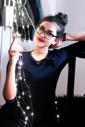 Woman Wearing Black Knit Elbow-sleeved Top Touching Mini String Lights