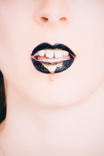 Woman Wearing Black Lipstick With Gold Dripping Out