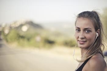Woman Wearing Black Tank Top And White Earbuds