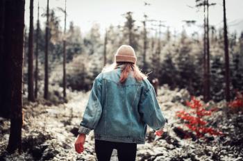 Woman Wearing Blue Denim Jacket and White Beanie Walking in the Forest