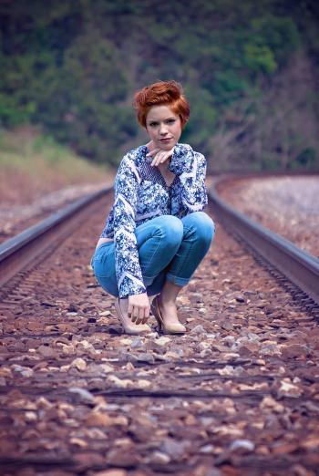 Woman Wearing Blue on Train Track during Daytime