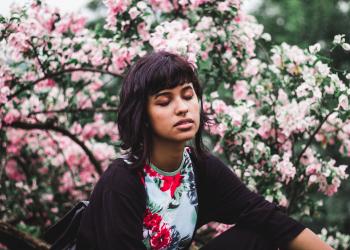 Woman Wearing White and Red Floral Crew-neck Shirt Near Pink Petaled Plant