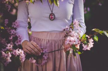 Woman Wearing White Long Sleeve Shirt and Beige Skirt Holding Pink Petaled Flower