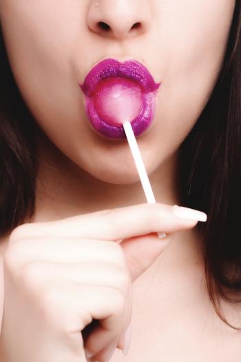 Woman With Pink Lipstick Licking Strawberry Lollipop