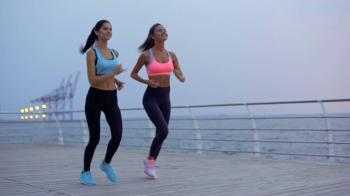 Two beautiful young smiling sports women jogging on beach Stock ...