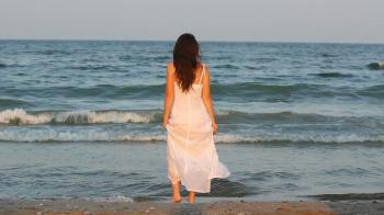 Beautiful woman on seashore, long hair in the breeze, water sea ...