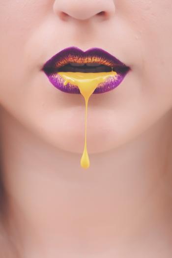 Women's Purple and Yellow Lips With Yellow Liquid