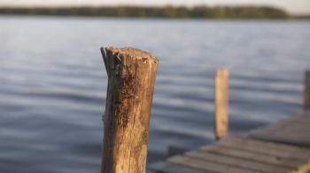 Female hand with dripping water drops on wooden pole of a small ...