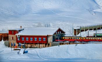 Yellow and Red Train Beside Snowy Mountain