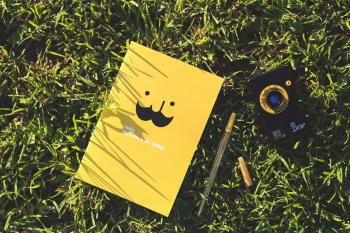 Yellow notebook on the grass