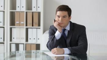 Young businessman thinking over the text of the business notice ...