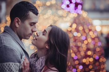 Young Couple Kissing in City at Night