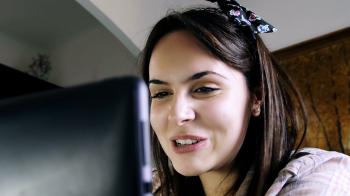 funny young woman chat with someone using her laptop and the webcam ...