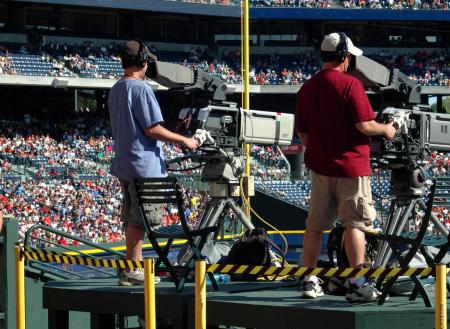 2 Camera Man Standing in a Green Metal Stage during Daytime