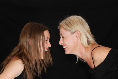 2 Women Smiling Near Black Textile