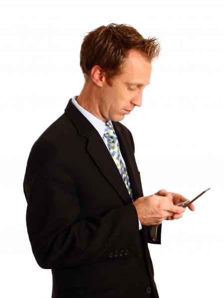 A businessman texting on a cell phone
