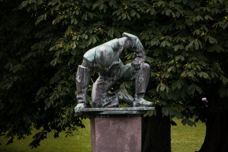 A sculpture of tired or humble man