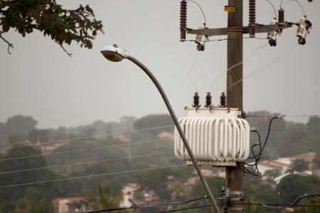 A streetlight and transformer post in the rain