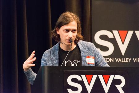 Aaron Lemke of Unello Design giving 60 Second Pitch at SVVR (right hand raised and spread)