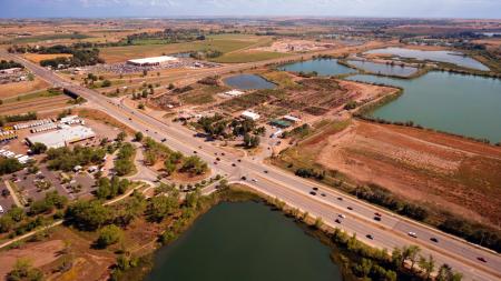 Aerial Photography of an Open Road With Cars Near City and Lake during Daytime