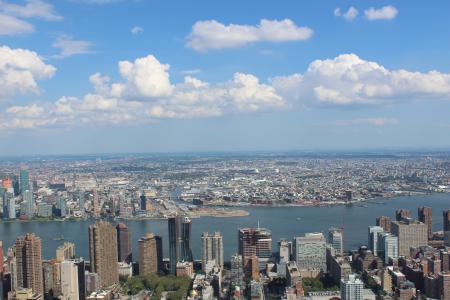 Aerial View of City Buildings by River Under Blue Cloudy Skies