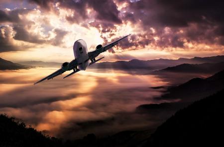 Airplane Flying Under White Clouds during Night Time