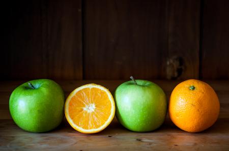 Apple and orange fruit on brown wood