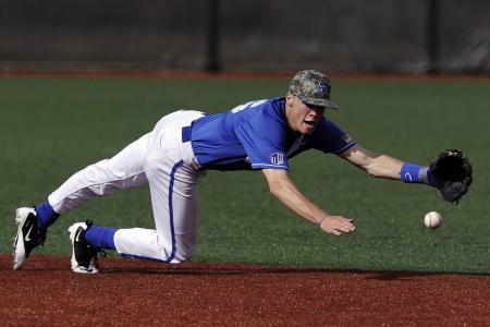 Baseball Player Wearing Blue and White Jersey Catching Baseball