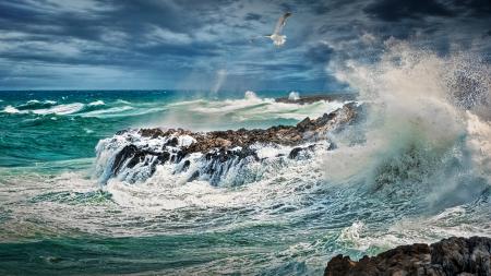 Beach Beside Stone Formation With Waves at Daytime