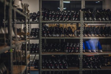 Black and Blue Ice Skates on Gray Metal Shelf Inside White Room