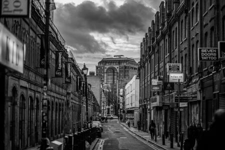 Black and White Photo of Street and Builldings With People