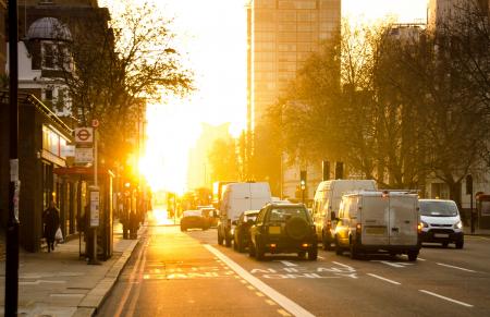 Black and White Vehicles Traveling on Gray Asphalt Road during Sunset