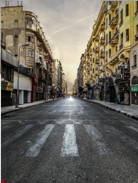 Black Asphalt Road Between Brown City Building Under White Skies during Daytime