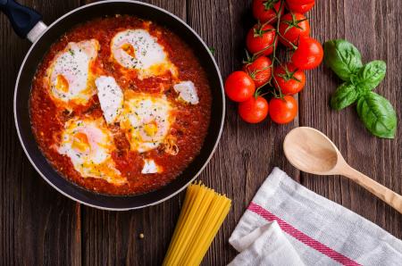 Black Frying Pan With Spaghetti Sauce Near Brown Wooden Ladle and Ripe Tomatoes