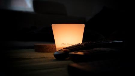 Black Remote Control Near Lamp Inside Dark Room