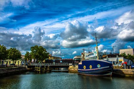 Blue and White Ship in Front of Concrete Structure