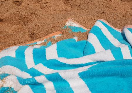 Blue and white towel on the sand