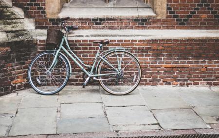 Blue Bicycle Parked on Brown Bricked Wall