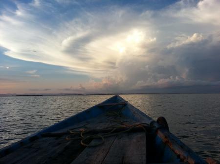 Blue Rowboat on Water Under White Clouds during Daytime