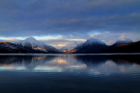 Body of Water in a Distant of Mountains Under White Clouds