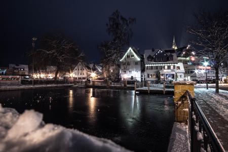 Body of Water Infront of White 3-storey Houses during Night Time