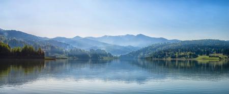 Body of Water Next to Mountain during Day Time