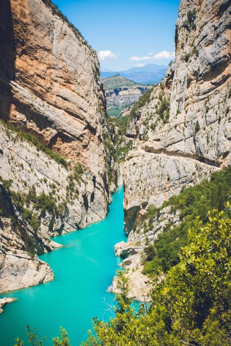 Body of Water Surrounded by Mountain Under Blue Sky at Daytime