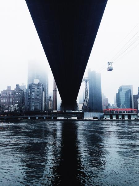 Body of Water Under Bridge Near Buildings Under White Clouds during Cloudy Day