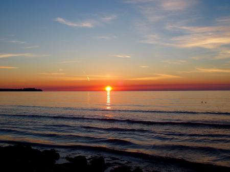 Body of Water With Orange Sun Setting during Golden Hour