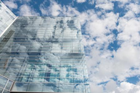 Bottom View of Clear Glass Building Under Blue Cloudy Sky during Day Time