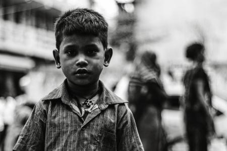 Boy in Collared Button-up Shirt Standing Near Two Person Walking