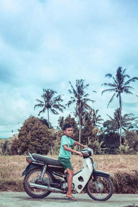 Boy Riding on White and Red Underbone Motorcycle