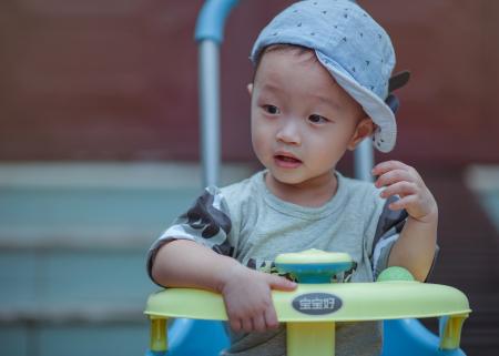 Boy Sitting on Yellow and Blue Trike