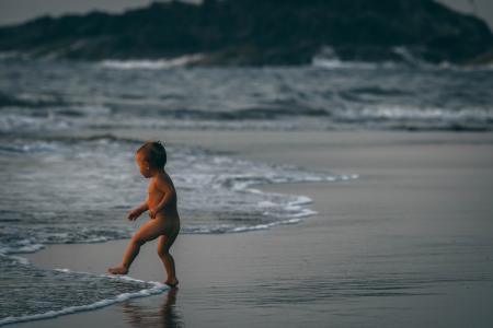 Boy Standing Beside Seashore Waves